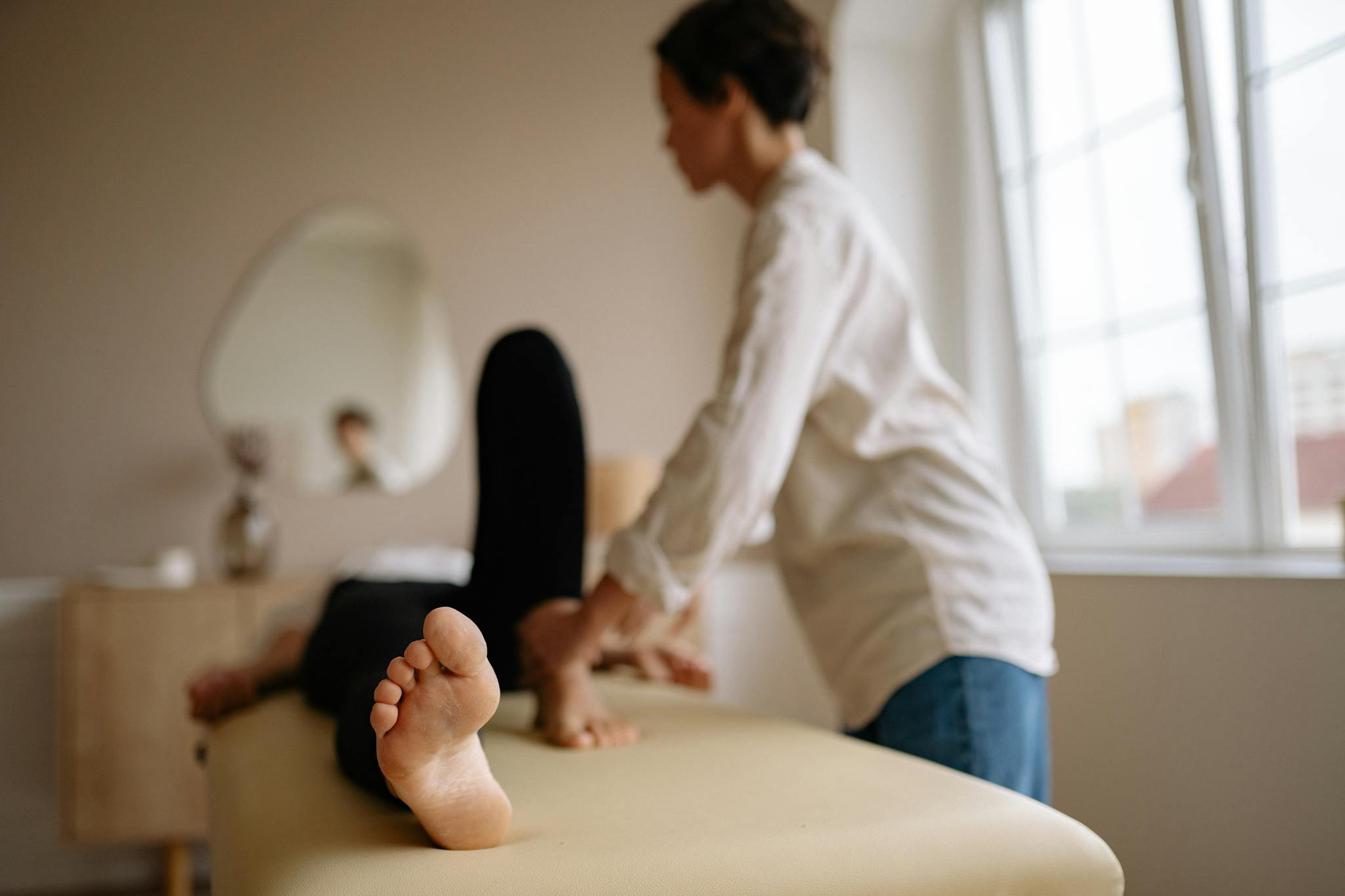 A calming foot massage in a serene indoor spa environment with natural light.